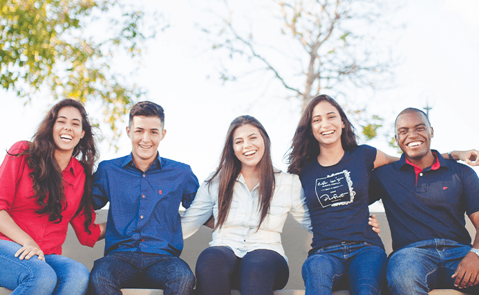 photo de 5 étudiants (3 filles et 2 garçons) souriants et assis les uns à côté des autres sur un banc